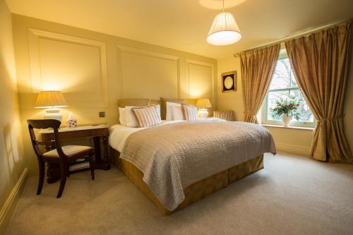a bedroom with a bed and a desk and a window at The Cornmill in Kirkbymoorside