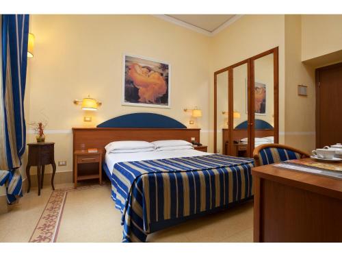 a hotel room with two beds and a mirror at Hotel Kennedy in Rome