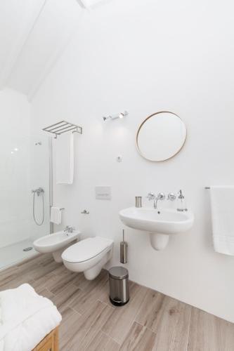 a white bathroom with two sinks and a mirror at Insula Vinus Apartments in Madalena