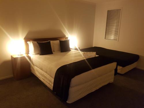 a hotel room with two beds and two lamps at Trendy Bungalow in the Heart of Rotorua in Rotorua