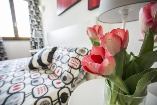 a vase filled with pink flowers in front of a couch at B&B casa73 in Cicerale