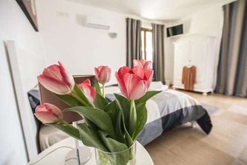 a vase of pink flowers on a table in a bedroom at B&B casa73 in Cicerale