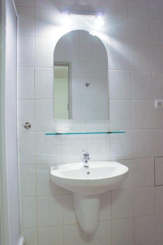 a white bathroom with a sink and a mirror at Dziwnów Wczasowisko in Dziwnów