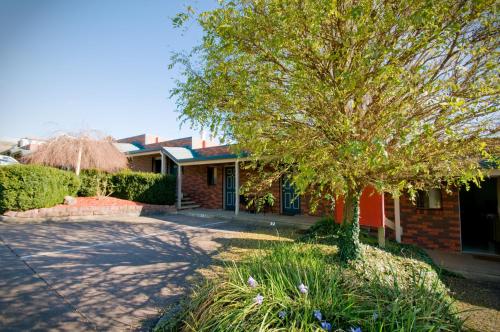 a house with a tree in front of a driveway at Warragul Views Motor Inn in Warragul
