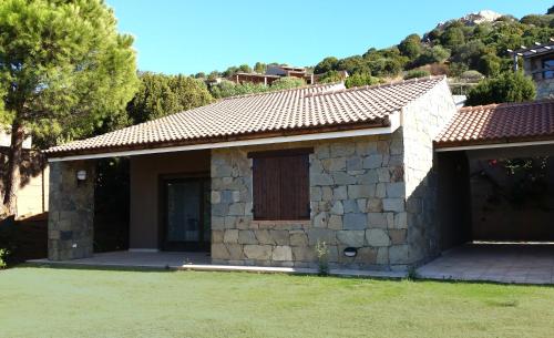 a small stone house with a door and a yard at Casa Bithia in Chia
