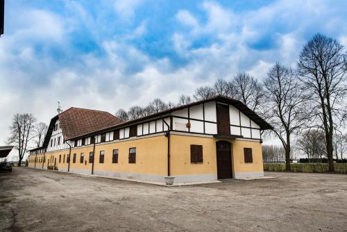 a large yellow building with a brown roof at Agriturismo Tenuta "Il Cigno" in Villanterio
