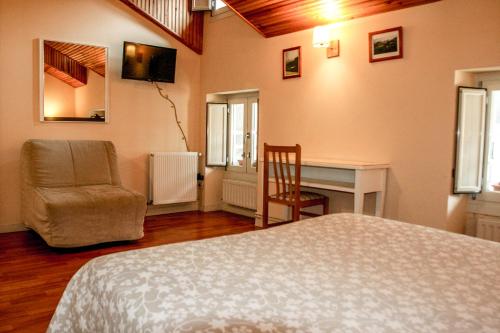 1 dormitorio con cama, silla y escritorio en Eco Hotel Mundaka en Mundaka