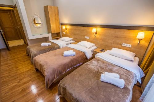a hotel room with three beds with towels on them at Apartment Sweet Home at Freedom Square 2 in Tbilisi City
