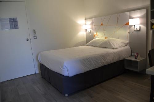 a bedroom with a large bed with two lights on it at Hotel du Parc Euromédecine by AKENA in Montpellier