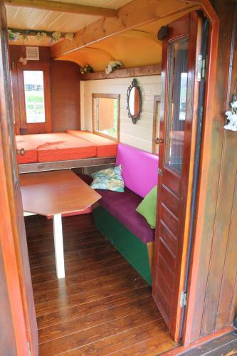 een kleine kamer met een bank en een tafel bij Pipowagen in Tynaarlo
