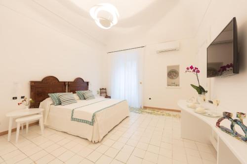 a white bedroom with a bed and a sink at Dimore De Luca in Amalfi
