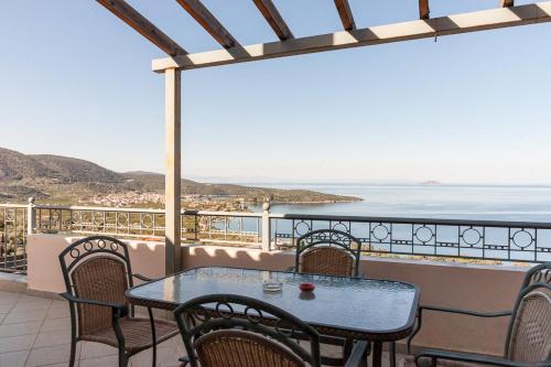 a table and chairs on a balcony with a view of the ocean at Epidavros Seascape in Ancient Epidavros