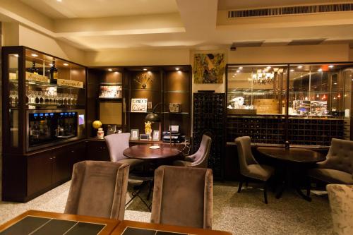 a restaurant with tables and chairs and a bar at Eureka in Tainan