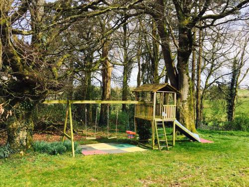 a playground in a park with a tree at The Brook in Enniskillen