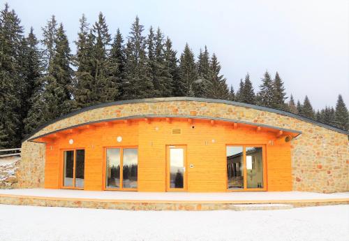 a building with a round roof with trees in the background at EA Horský Hotel Hájenka in Modrava