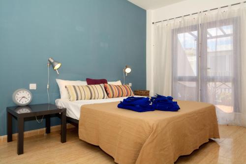 1 dormitorio con 1 cama y reloj sobre una mesa en Top Charco San Gines Stunning View Lanzarote By PVL, en Arrecife