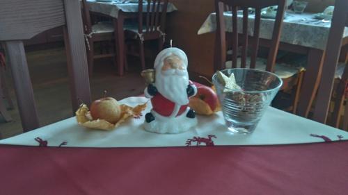 a santa claus figurine on a table next to a glass at Agritur Leita in Tuenno