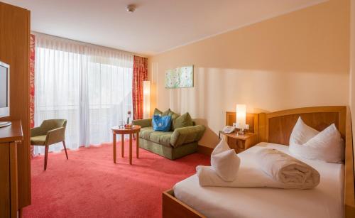 a hotel room with a bed and a couch at Vivea Hotel Umhausen im Ötztal in Umhausen