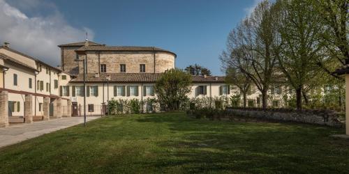 a large building with a grass yard in front of it at Hotel Cortaccia Sanvitale in Sala Baganza