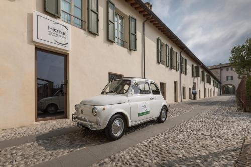 a small white car parked in front of a building at Hotel Cortaccia Sanvitale in Sala Baganza