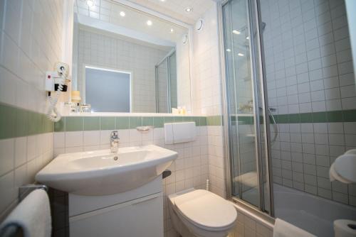 a bathroom with a sink and a toilet and a shower at Parkhotel Styria in Steyr