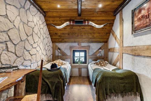 - 2 lits dans une chambre avec un mur en pierre dans l'établissement J A Ranch Bed & Breakfast, à Strömsnäsbruk