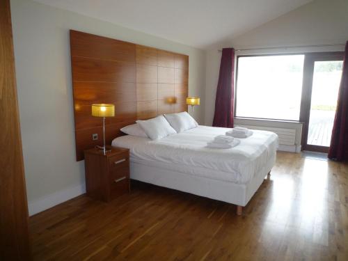 a bedroom with a bed and a large window at Castlemartyr Holiday Lodges 3 Bed in Castlemartyr