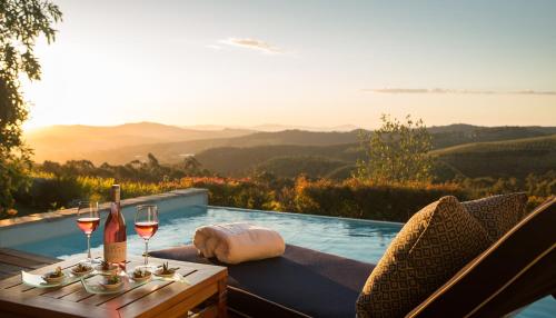 einen Tisch mit Weingläsern und eine Flasche Wein in der Unterkunft Delaire Graff Lodges and Spa in Stellenbosch