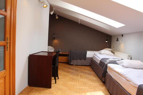クラクフにあるCracow Old Town Guest Houseのベッドが2つと机がある部屋