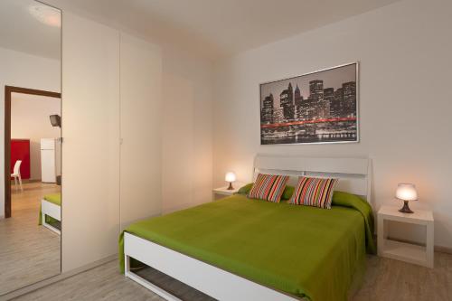 sypialnia z zielonym łóżkiem z 2 poduszkami w obiekcie Residence Eur w mieście Sottomarina