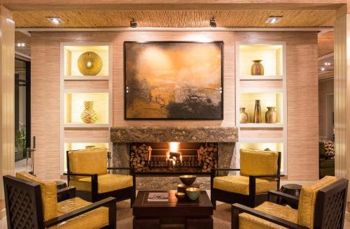 ein Wohnzimmer mit Kamin und einem Gemälde an der Wand in der Unterkunft Delaire Graff Lodges and Spa in Stellenbosch