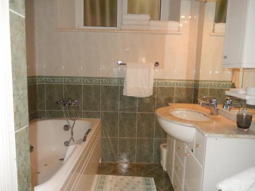 uma casa de banho com uma banheira e um lavatório e uma banheira em Apartment Dalija em Dubrovnik