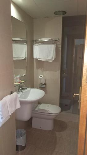 a bathroom with a white sink and a toilet at Hostal Mediterraneo in El Ejido