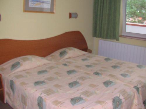 a bed in a bedroom with a bedspread on it at Hotel Seasons in Tryavna