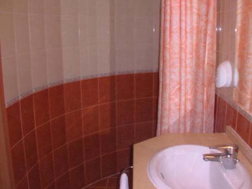 a bathroom with a sink and a shower curtain at Hotel Seasons in Tryavna