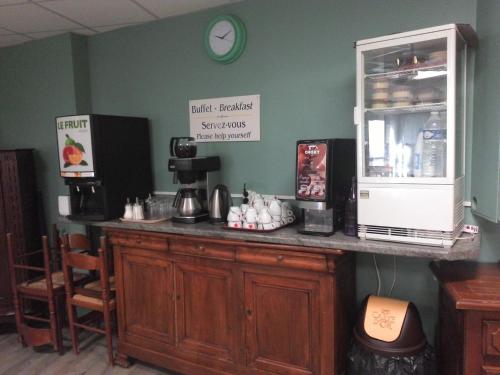 een aanrecht in een koffiehuis met een klok aan de muur bij Hotel De La Paix in Albert