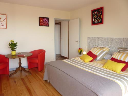 a bedroom with a large bed and a table at Les Terrasses de Bellemoure Cébazat in Cébazat