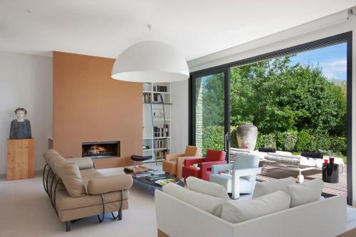 un salon avec des meubles blancs et une grande fenêtre dans l'établissement BB 12 LUBERON chambres d'hôtes contemporaines, à Gordes