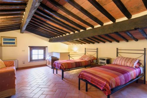 um quarto com duas camas e um sofá em CASA DI CHIARILU' em Cortona