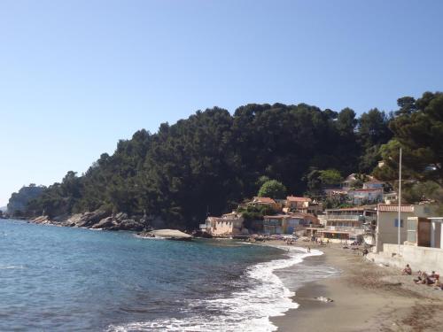 a beach with a group of people on the shore at Studio du Pouverel in La Garde