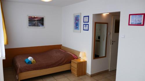 a small bedroom with a bed and a mirror at Apartamenty Olimp in Gdańsk