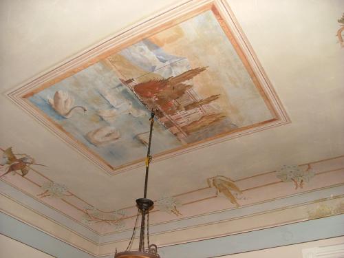 a painting on the ceiling of a room with a chandelier at Palazzo Lagioia in Triggiano