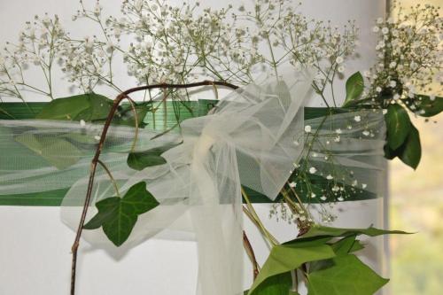 a plant with white flowers in a vase with a veil at Hotel Salobreña Suites in Salobreña