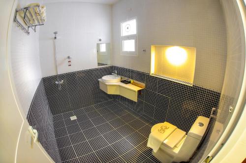a bathroom with a toilet and a sink and a mirror at Zaki Hotel Apartment in Sur