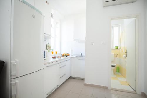 cocina blanca con armarios blancos y ventana en Apartments Goda Center Of Split, en Split