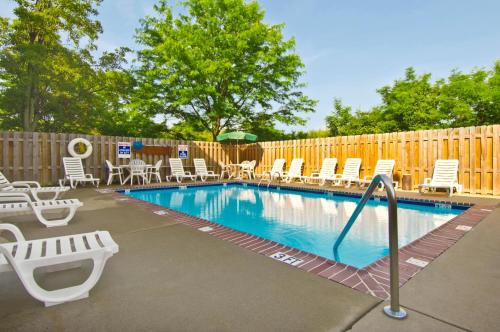 einen Pool mit Stühlen und einem Zaun in der Unterkunft Extended Stay America Suites - Jackson - Ridgeland in Ridgeland