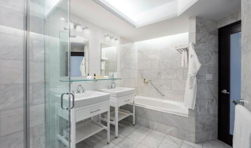 a bathroom with a tub and a sink and a shower at Condado Vanderbilt Hotel in San Juan