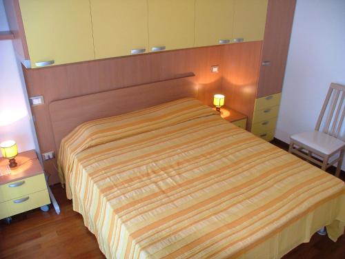 - une chambre avec un lit, une chaise et un miroir dans l'établissement Residence Magnolia, à Grado