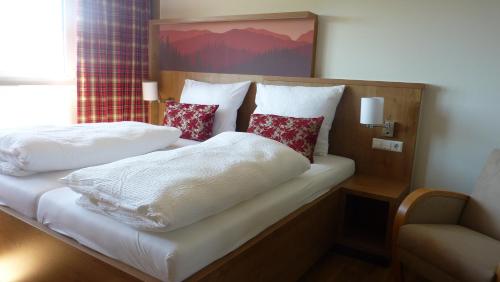 a bedroom with two beds with white blankets and pillows at Gasthaus Sonne Neuhäusle in Sankt Märgen