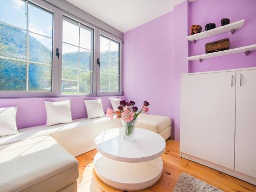 a purple living room with a white couch and a table at Apartments Princess View in Sveti Stefan